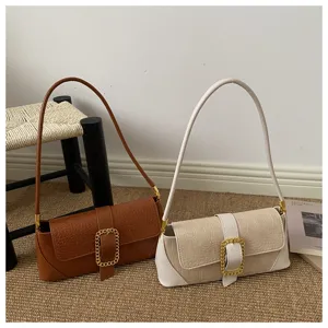 Elegant crocodile embossed baguette bags in brown and cream featuring ornate gold buckles.