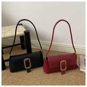 Detailed view of crocodile texture baguette bags with golden buckle in black and red