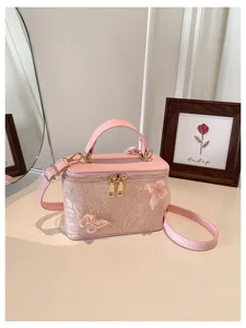 Vista dettagliata dell'elegante borsa da sera in jacquard rosa con decoro a farfalla