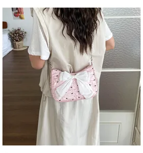 Fashionable pink seersucker shoulder bag featuring a large white bow and cute bow print