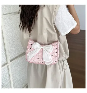 Chic pink seersucker shoulder bag with oversized white bow and black bow patterns