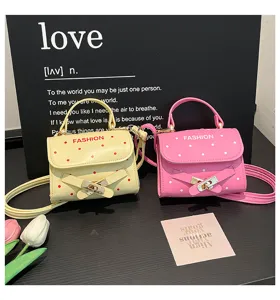 Stylish polka dot mini handbags in yellow and pink, featuring decorative buckles.