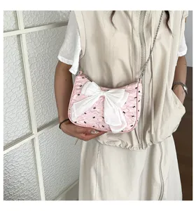 Fashionable pink seersucker underarm shoulder bag with a large white bow accent