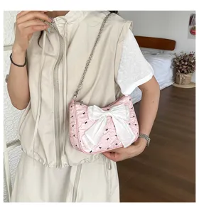 Elegant pink seersucker underarm bag with a large white bowknot decoration on a model.