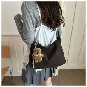 Grand sac fourre-tout marron vintage avec un ours en peluche porté par un mannequin.