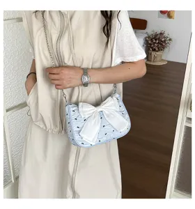 Close-up of a light blue bubble gauze shoulder bag featuring a large white bow detail