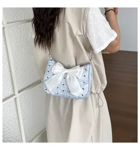 Stylish blue bubble gauze shoulder bag with a large white bow decoration in use
