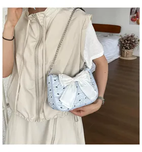 Close-up of a stylish light blue seersucker shoulder bag featuring a large white bowknot