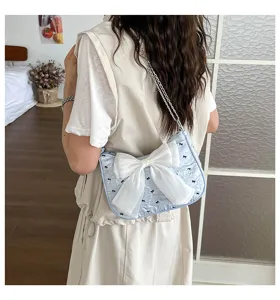 Detailed view of light blue bubble gauze shoulder bag with a large white decorative bow