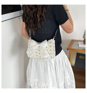 Detailed back view of a cream bubble gauze shoulder bag with a large white bow and embroidery
