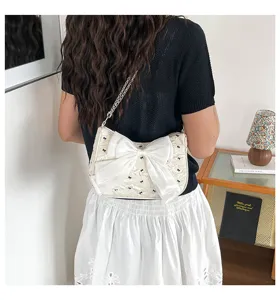 Stylish white bubble gauze underarm bag with large satin bow and chain strap