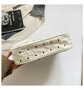 Close-up of white bubble gauze tote bag with black bow embroidery details