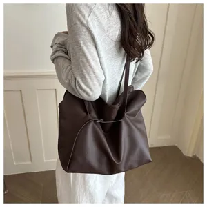 Minimalist dark brown leather tote bag with large capacity shown as an underarm bag