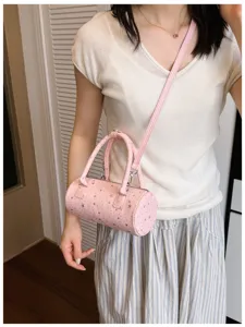 Vue détaillée du sac polochon rose à motif étoiles avec une tenue d'été décontractée.