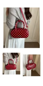 Lifestyle view of a red oval handbag with white polka dots and adjustable shoulder strap