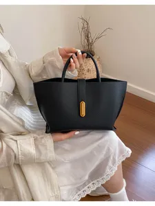 Detalle de bolso tote vintage en cuero granulado negro con cierre metálico dorado