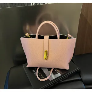 Primer plano de bolso tote de cuero rosa con cierre giratorio dorado sofisticado