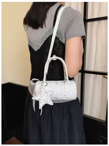 Sac polochon blanc avec motifs d'étoiles et grand charm d'étoile porté par un mannequin