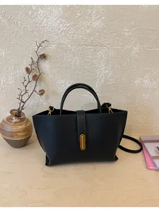 Primer plano elegante de bolso tote de cuero granulado negro vintage con hebilla dorada