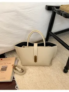 Detalle de bolso tote de cuero beige con cierre de metal de estilo vintage