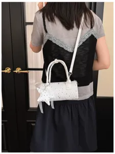 Vue détaillée d'un sac tonneau blanc à motifs d'étoiles porté comme sac à bandoulière
