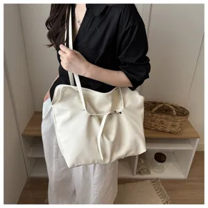 Fashionable minimalist large capacity white leather tote bag shown being carried by a model