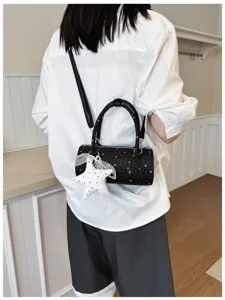 Vue de dos d'un modèle portant un sac polochon noir étoilé avec breloque étoile