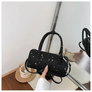 Gros plan d'un sac polochon noir imprimé étoiles avec une bandoulière et des poignées doubles