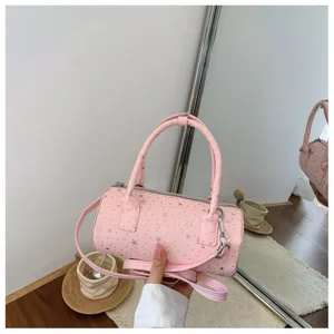Détail d'un sac polochon rose avec des motifs d'étoiles argentées et des accents de clous