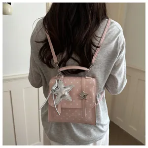 Rückansicht eines rosa gepunkteten Rucksacks mit einem silbernen Sternanhänger.