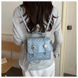 Rückansicht eines stilvollen hellblauen gepunkteten Rucksacks mit metallischen Sternendetails.