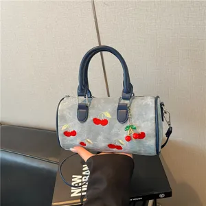 Trendy denim Boston bag featuring cherry embroidery and matching charm for summer commute