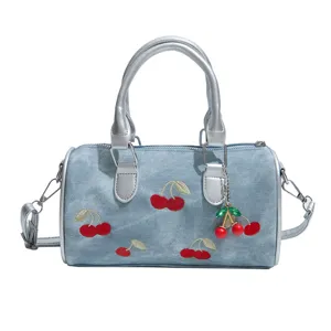 Stylish blue denim Boston handbag featuring red cherry embroidery and a matching charm