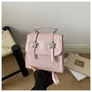 Detailansicht eines stylischen rosa gepunkteten Rucksacks mit sternförmigen Metallschnallen