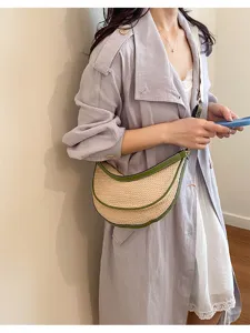 Vue du sac en paille tressée semi-circulaire porté par un mannequin en manteau léger