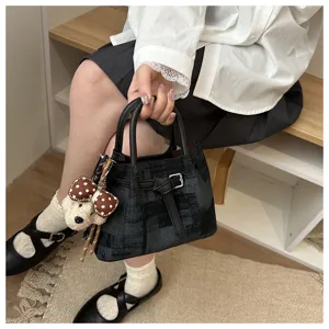 Retro textured bucket bag with a cute teddy bear pendant shown in a lifestyle setting