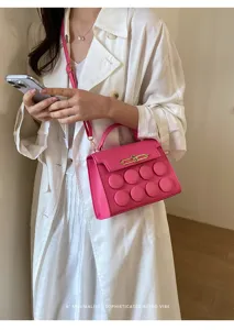 Detail view of vibrant pink crossbody bag with unique bubble texture design