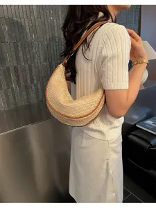 Détail montrant la texture d'un sac demi-lune en paille tressée avec bordure en cuir marron
