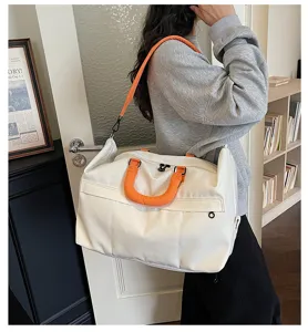 Large capacity white travel duffel bag with vibrant orange handles for women and men.