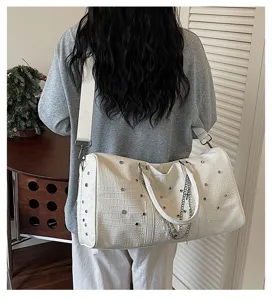 Detailansicht der weißen Krokodilmuster Reisetasche mit Strasssteinen und Kette für Damen.