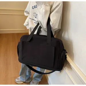 Large capacity travel duffel bag detail showcasing durable black fabric and sturdy handles.
