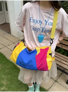 Detailed view of colorful color-block travel duffel bag showing large capacity and straps.