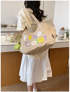 Casual canvas tote bag with embroidered letters and cute flower pendant for daily use.