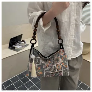 Modello con borsa a tracolla ricamata cinese con nappe e perline in legno