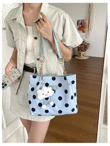 Detailed visual of a stylish light blue polka dot tote bag with cute cloud plush charm