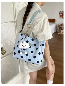 Detailed view of a light blue polka dot tote bag featuring a cute white cloud charm