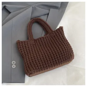 Gros plan d'un sac cabas marron foncé tricoté à la main avec un motif de laine texturé