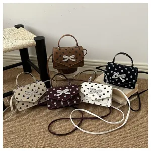 Vue détaillée de sacs bandoulière à pois avec nœud en strass en plusieurs couleurs