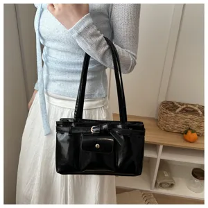 Close-up of vintage black soft faux leather tote bag carried by a model