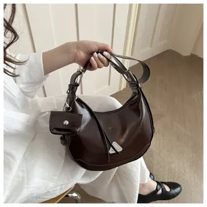 Detail view of dark brown leather crescent hobo bag with mini pouch attachment